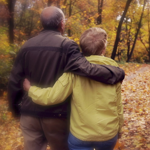 image of elderly couple walking in woods